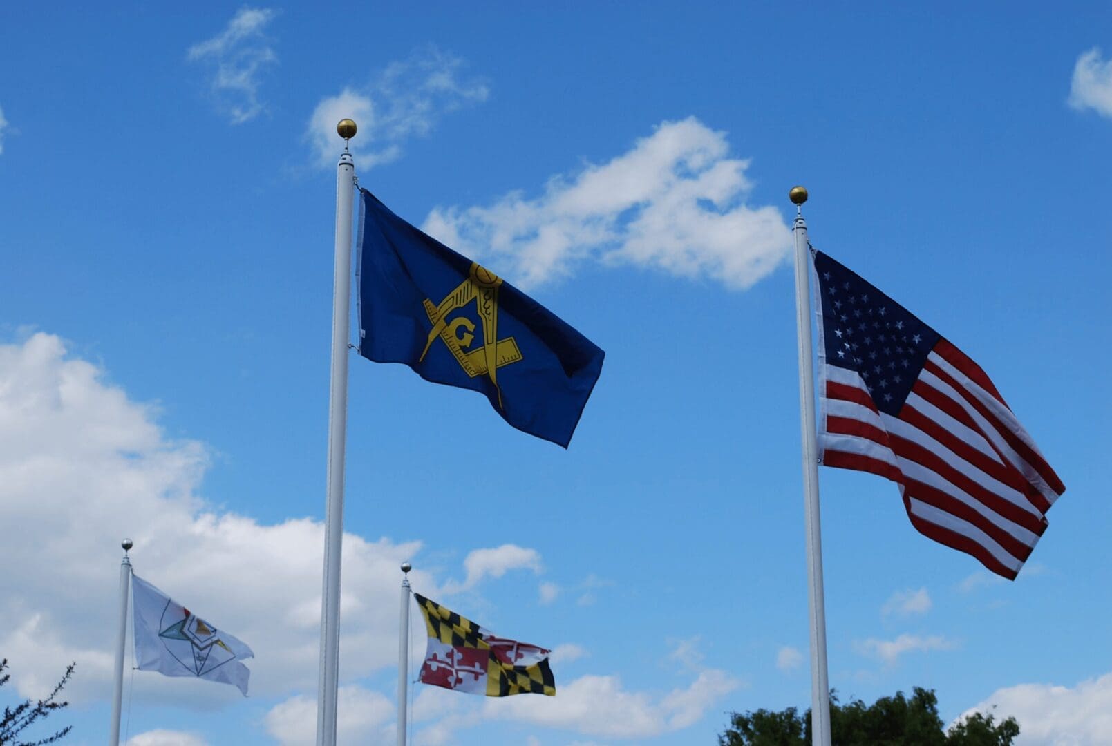 Masonic, US, and Maryland flags waving.